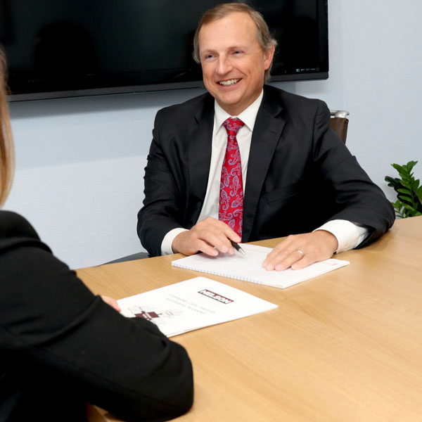 Joel J Garris smiling and pointing to document on table