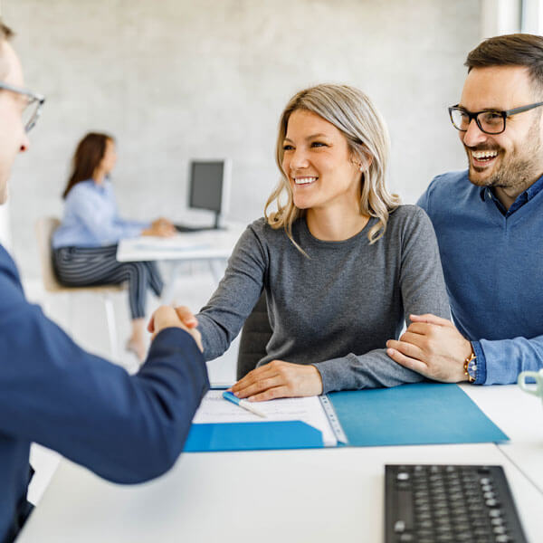 Happy couple came to an agreement with their financial advisor in an office