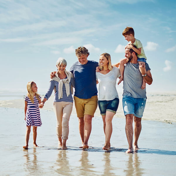 multi-generational family going for a walk together at the beach